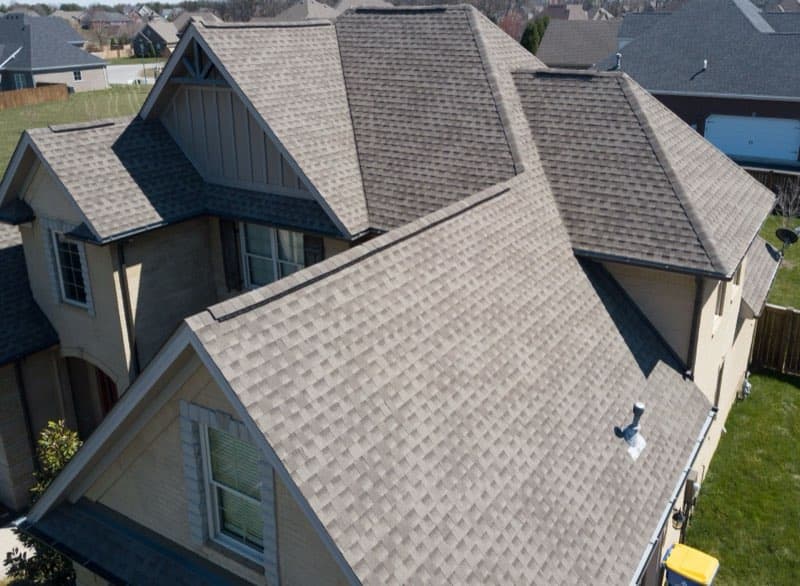 Roofer repairing shingles on a Des Moines, Iowa home